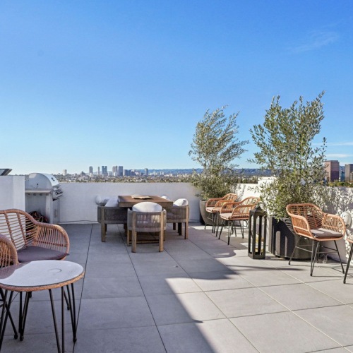 a deck with chairs and a tree
